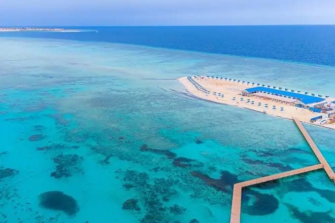 منظر جوي لشاطئ جزيرة بيانكا ورصيفها فوق مياه الشعاب الفيروزية