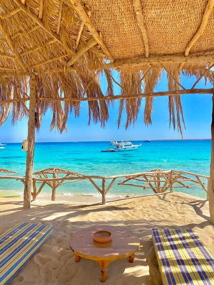 Sea view from under a straw shade with beach seating on Paradise Island