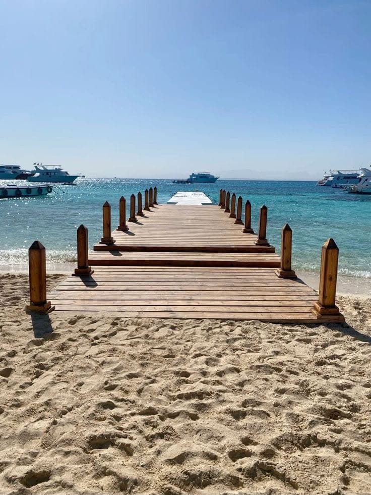 Wooden jetty stretching from the sand into the sea at Paradise Island